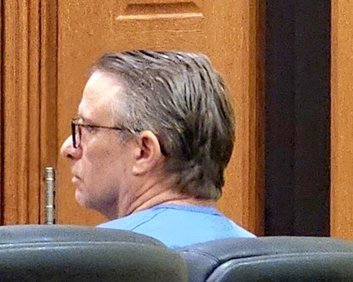 a man sitting in a chair in a courtroom
