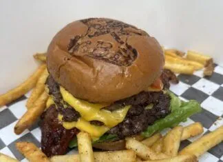 a cheeseburger with fries on a checkered table cloth