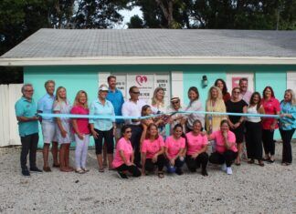 ISLAMORADA CHILD CARE CELEBRATES NEW LOCATION ON PLANTATION KEY a group of people in pink shirts holding a ribbon