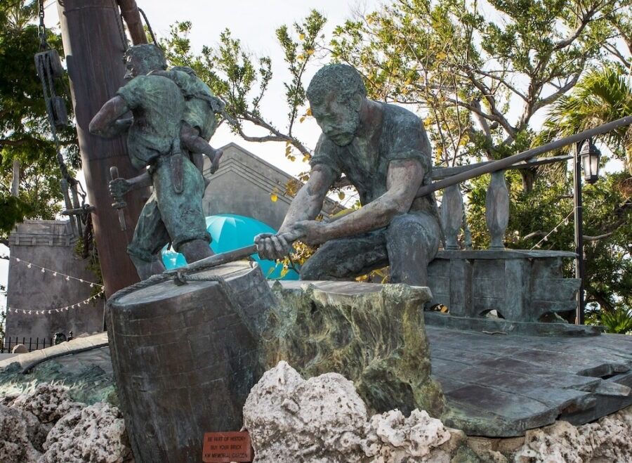 a statue of two men working on a piece of wood