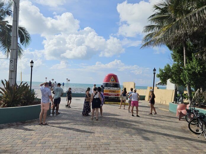temp Smost Point location by mandy a group of people walking down a sidewalk next to the ocean