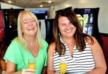 WANT TO BE FEATURED IN OUR NEXT KEYS WOMAN MAGAZINE? two women sitting at a table with drinks