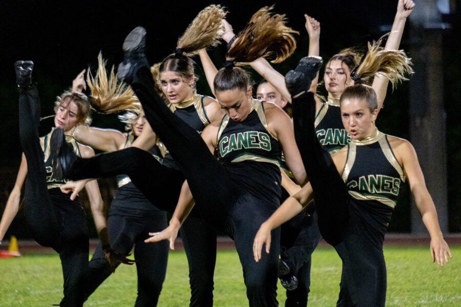 a group of girls in black and gold cheerleaders