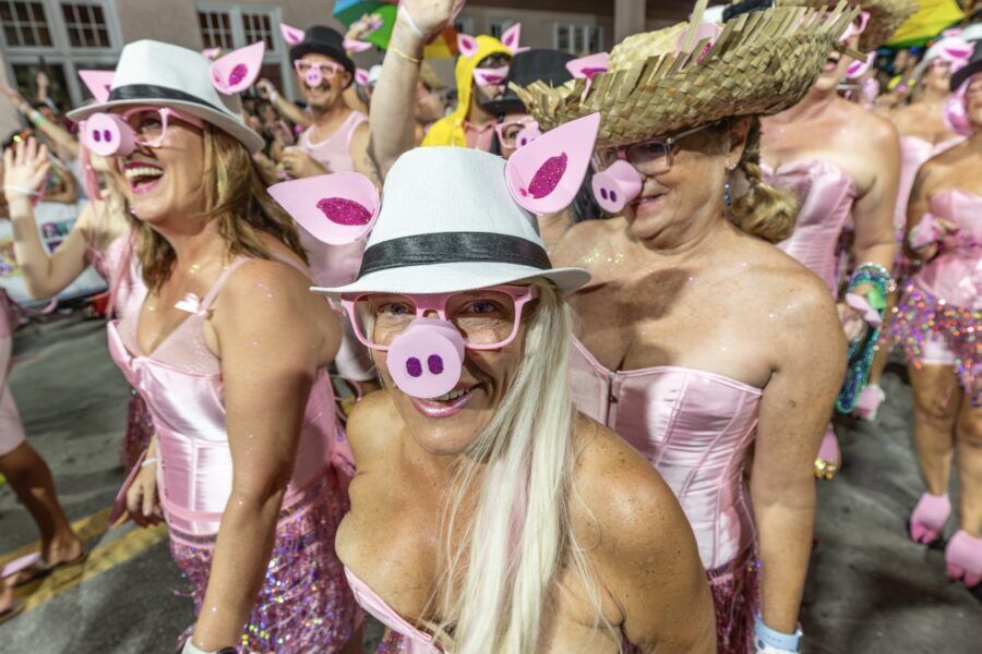 a group of women in pink dresses and hats