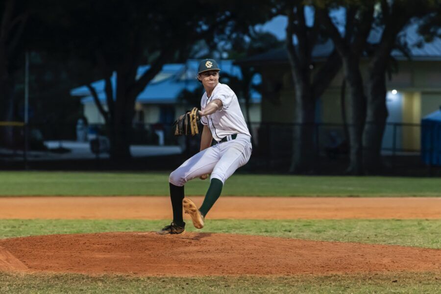 a baseball player pitching a ball on top of a field