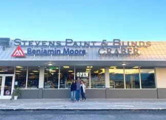 two people standing outside of a building