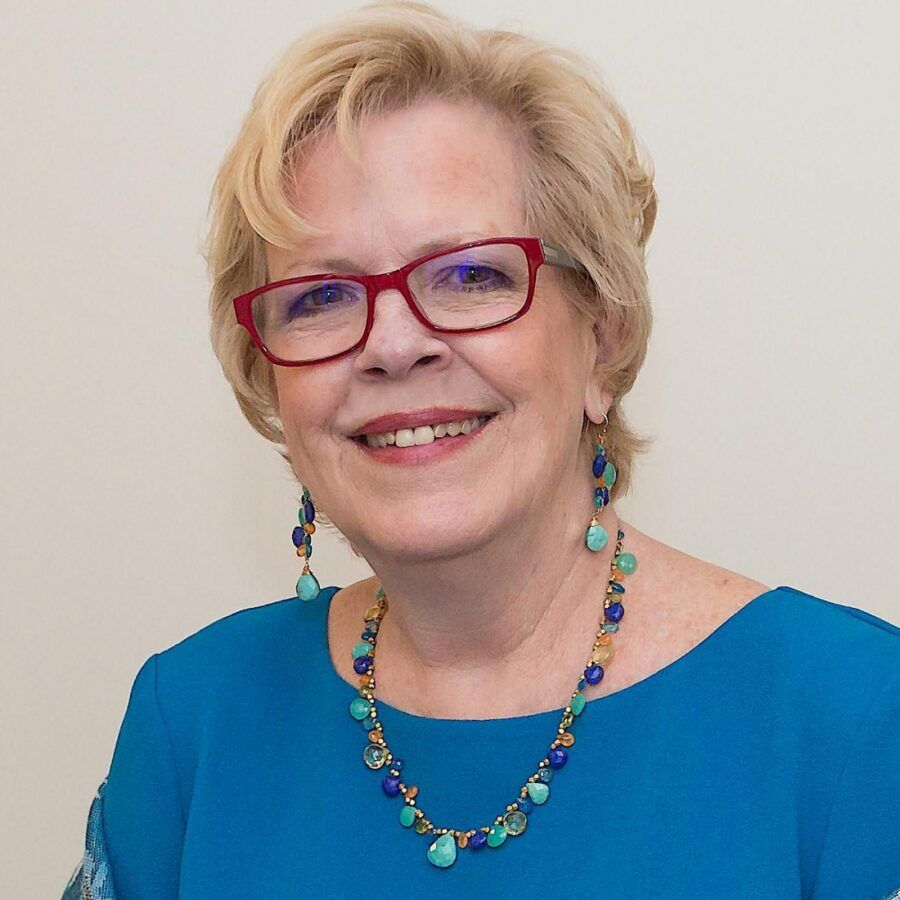 a woman wearing glasses and a blue top