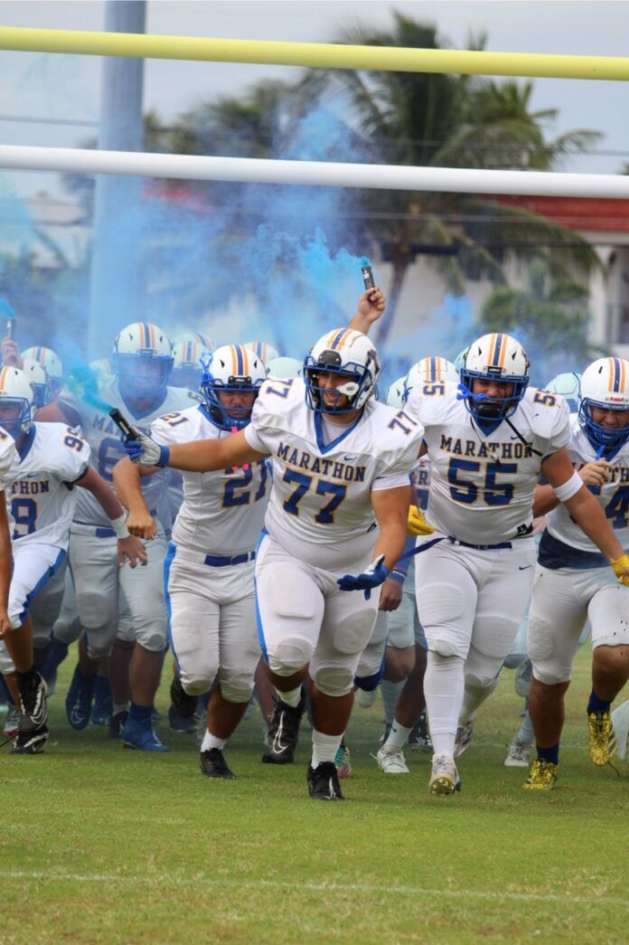 a football team running onto the field