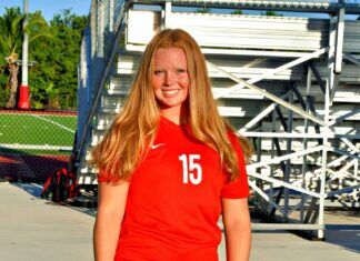 ATHLETE OF THE WEEK: MARY SEARCY a woman in a red shirt is posing for a picture