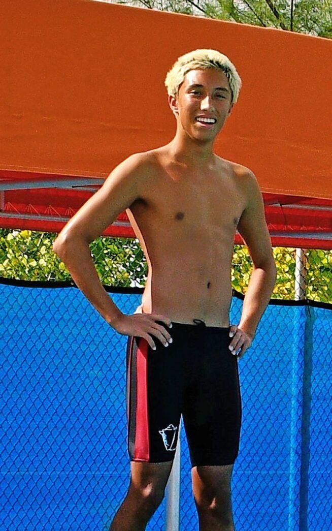 a man standing on a tennis court with his hands on his hips