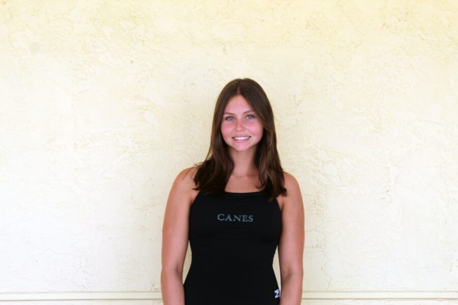 a woman standing in front of a white wall