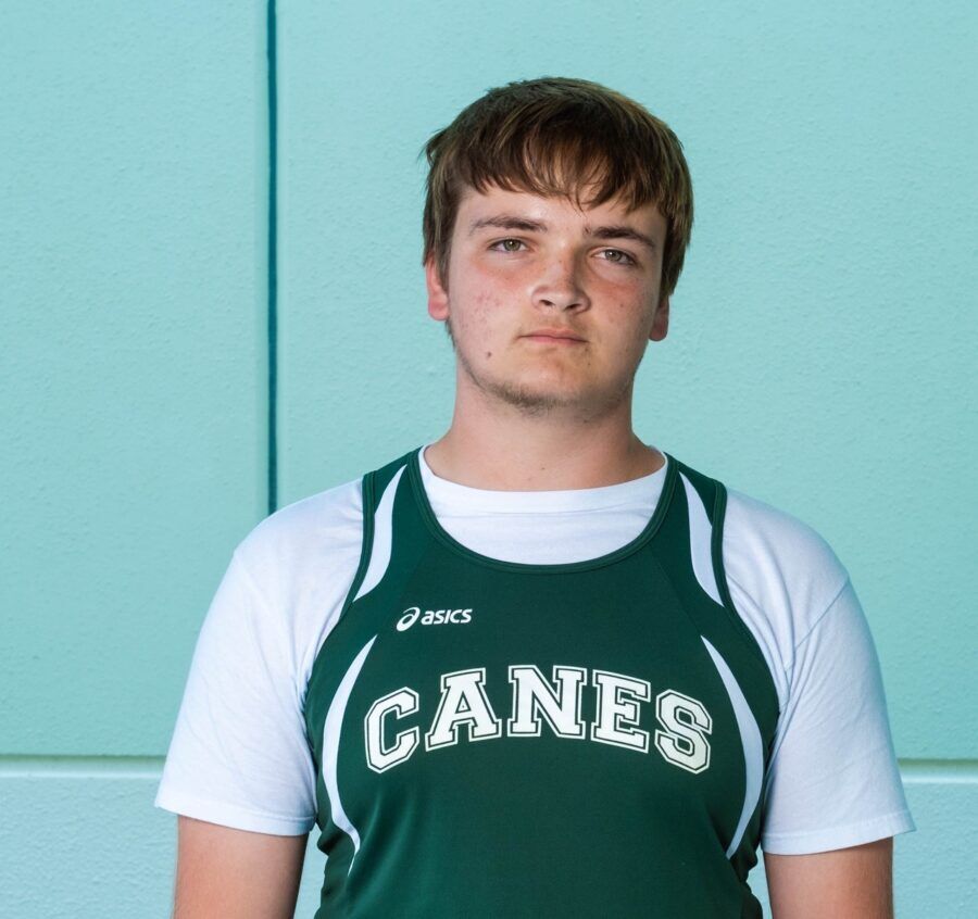 a young man wearing a green and white shirt
