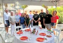 a group of people standing around a table