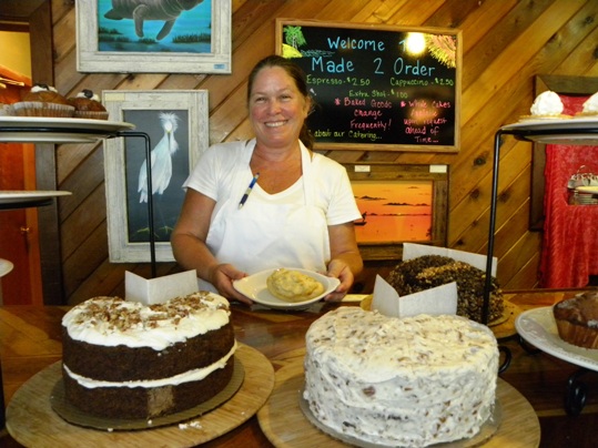 Susan Kramer sitting at a table in front of a cake - Bakery
