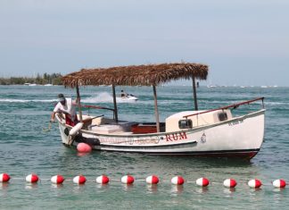A red and white boat sitting next to a body of water - Fish 'n Fun Boat & Watersports Rentals