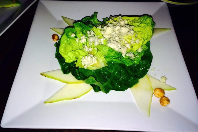 A white plate topped with meat and vegetables - Romaine lettuce