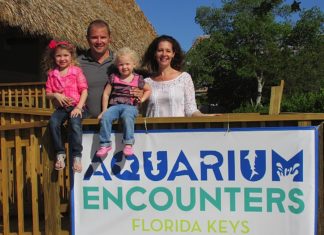 A group of people standing in front of a sign - Florida Keys Aquarium Encounters