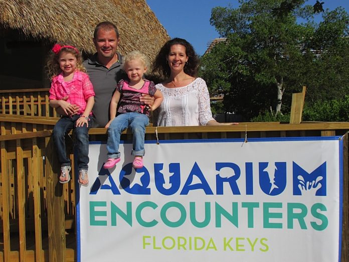 A group of people standing in front of a sign - Florida Keys Aquarium Encounters