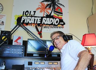 A man standing in front of a television playing a video game - Pirate Radio Key West