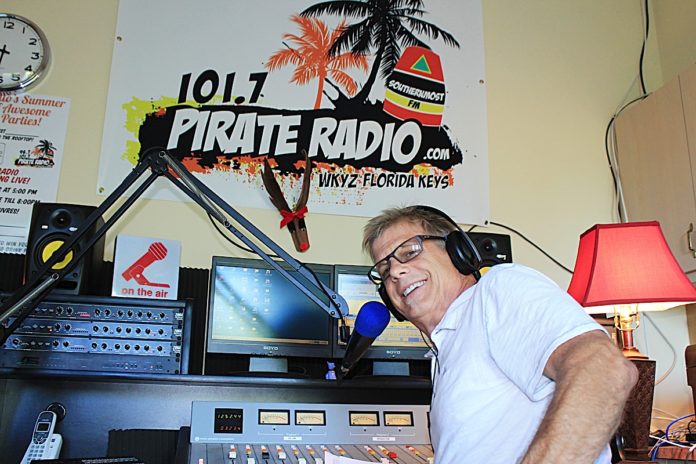 A man standing in front of a television playing a video game - Pirate Radio Key West