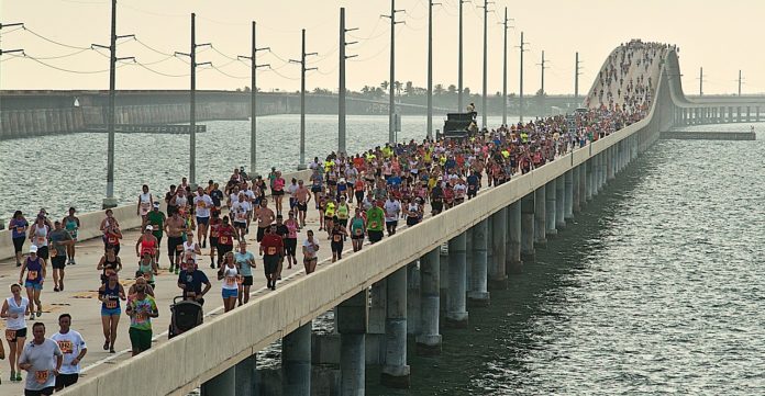 A group of people on a bridge over a body of water - Seven Mile Bridge