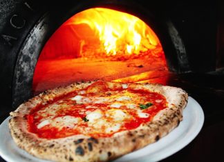 A pizza sitting on top of a stove - Sicilian pizza