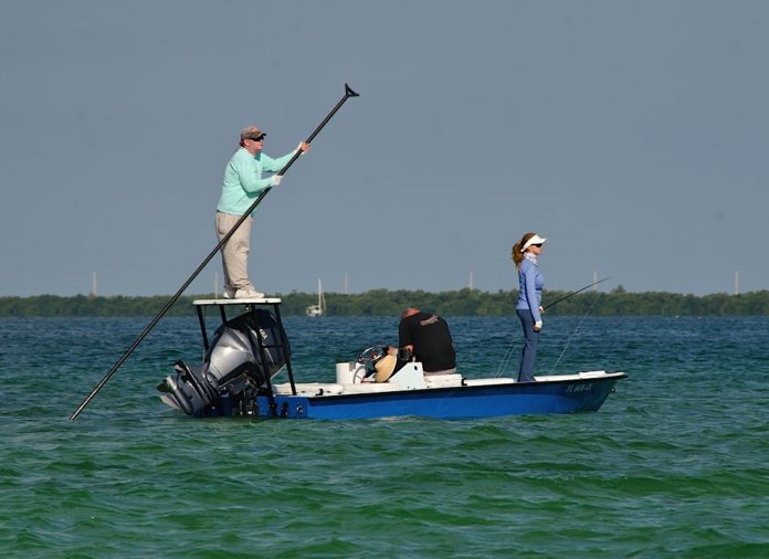 A group of people riding on the back of a boat in the water - Recreational fishing