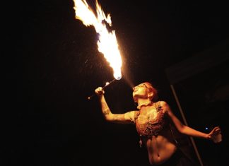 A person standing next to a fire - Performance art