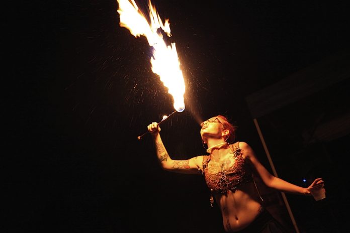 A person standing next to a fire - Performance art