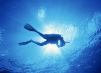 #News: Volunteer Divers Become Year-Round Asset - A man flying through the air while swimming in a body of water - Scuba diving