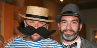 “One Mighty Party” - A man wearing a hat and glasses - Moustache