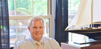 #News: Pete Chapman named chairman of the board - A person sitting in a chair in front of a window - Business