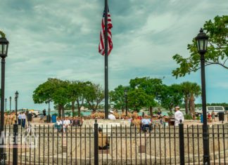 #NeverForget: Mallory Square honors 9/11 victims - A group of people standing next to a fence - Palm trees