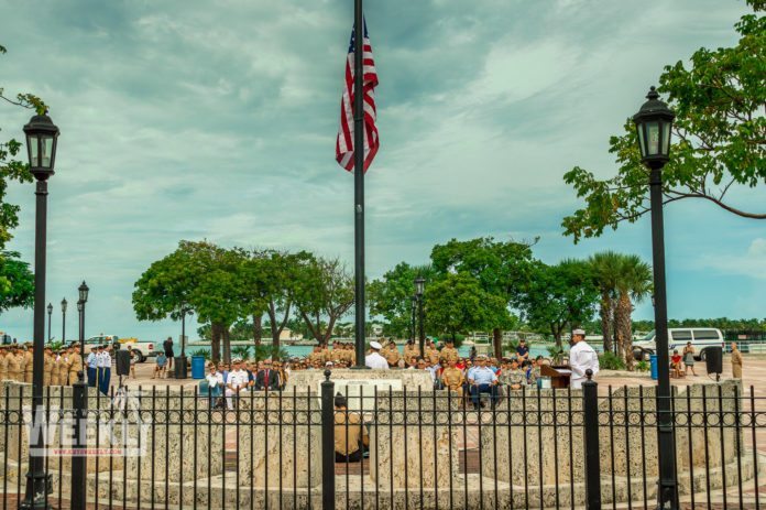 #NeverForget: Mallory Square honors 9/11 victims - A group of people standing next to a fence - Palm trees