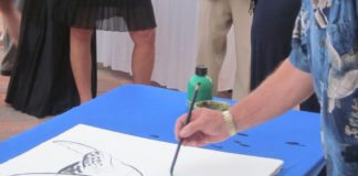 #Events: Wyland coming to art festival - A person holding a fish - Design