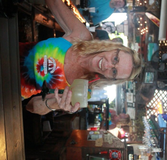 #Libation: Bartender Liz Lynch serves up her signature drink, the Lizarita. - A man standing in front of a store - Art