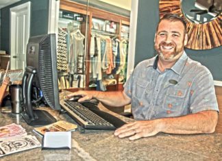 #LoveYourConcierge: Nate Boucree, Ocean Key Resort & Spa - A man sitting at a table with a laptop and smiling at the camera - Flooring