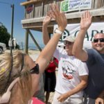#Events: Marathon Residents Win Stone Crab Eating Contest - A man holding a sign - Hawks Cay Boulevard