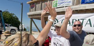#Events: Marathon Residents Win Stone Crab Eating Contest - A man holding a sign - Hawks Cay Boulevard