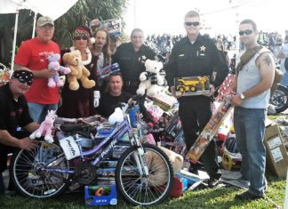 #News: Toy drive for needy kids coming to an end - A group of people standing next to a bicycle - Mountain bike