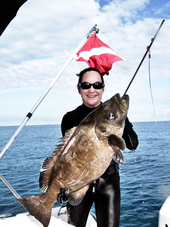 #Fish: The hunt for the black grouper - A man holding a fish on a boat in a body of water - Fishing