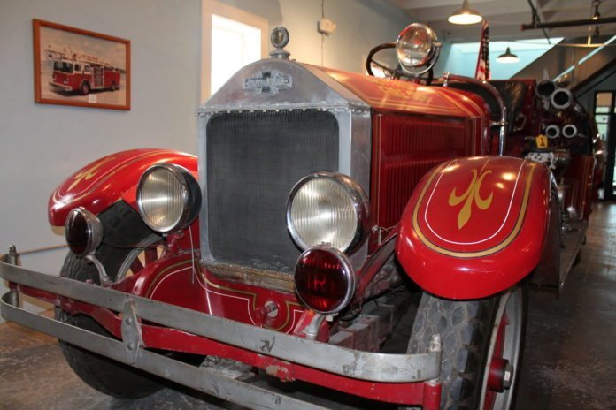 #News: Firehouse Museum preserves rich history - A red and black truck sitting on top of a car - Car