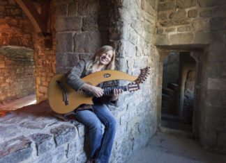 Acclaimed guitarist Muriel Anderson performs in Keys - A person sitting on a stone building - Muriel Anderson