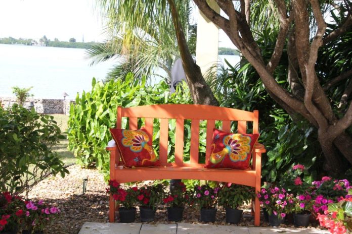 Marathon Garden Club hosts tour - A person sitting on a bench in a garden - Flower