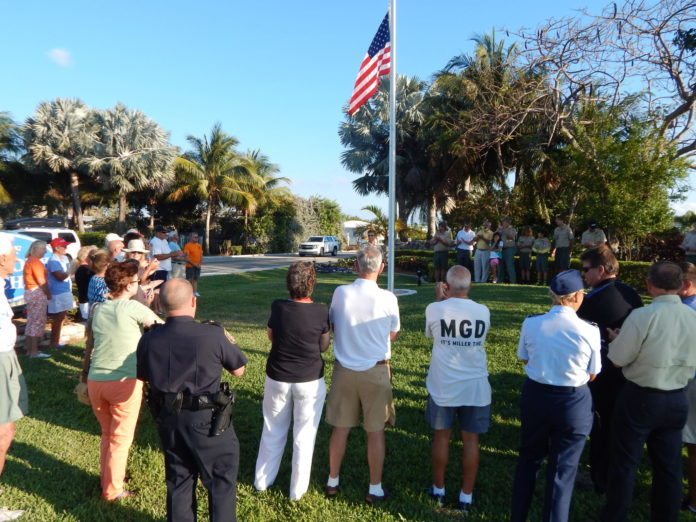 Scout responsible for new flagpole – Ben Ryder organizes project at entrance to Key Colony Beach - A group of people standing in the grass - Tree