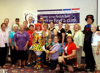 Relay For Life celebrates 20 years - A group of people standing in front of a crowd posing for the camera - Public Relations