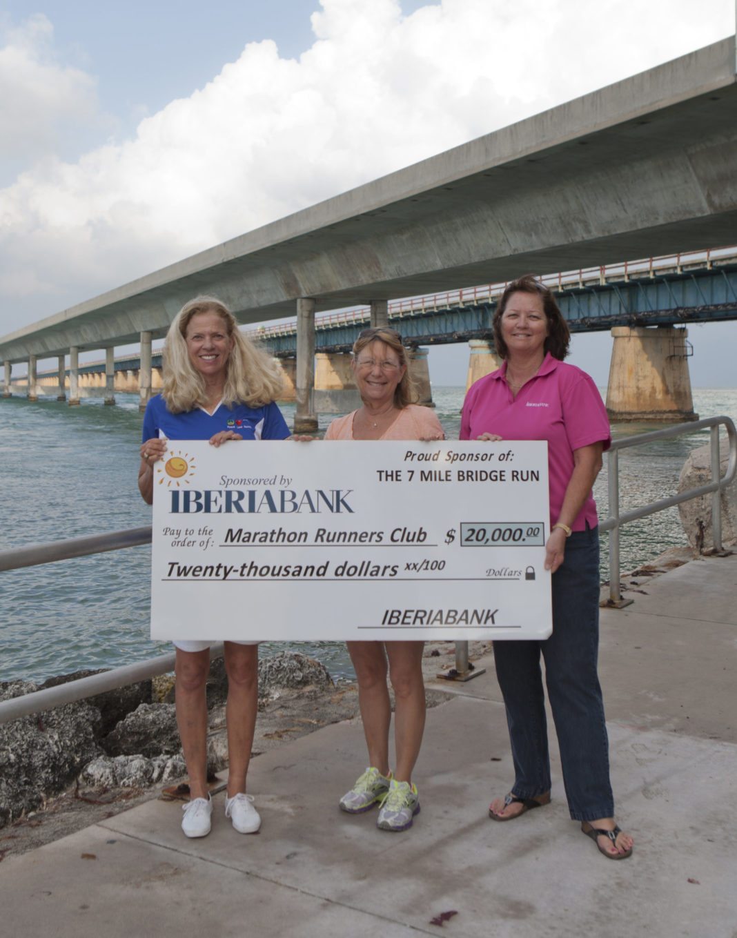 IBERIABANK Serves as Title Sponsor for Marathon’s 34th Annual 7 Mile Bridge Run - A person holding a sign posing for the camera - Water