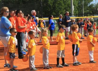 Hit, run, score! Opening ceremonies for MYC baseball season - A group of people standing in front of a crowd - College softball