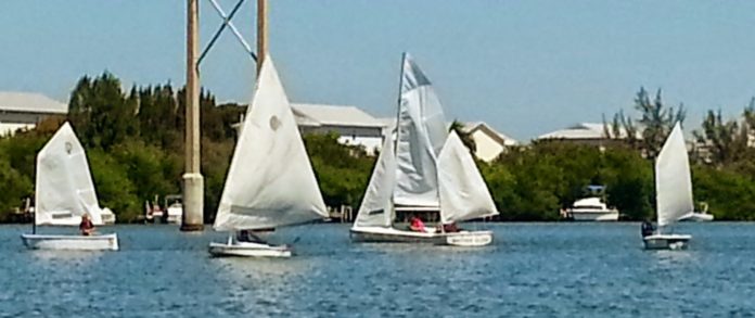 Kids learn to sail at summer camp - A small boat in a body of water - Sail