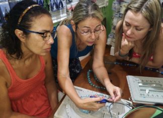String some beads in Key West String some beads in Key West - A group of people looking at a laptop - Key West